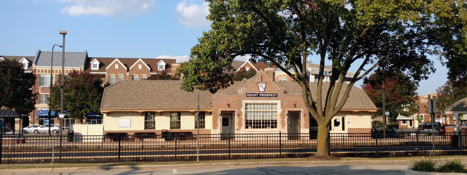 A train station featuring a building surrounded by trees